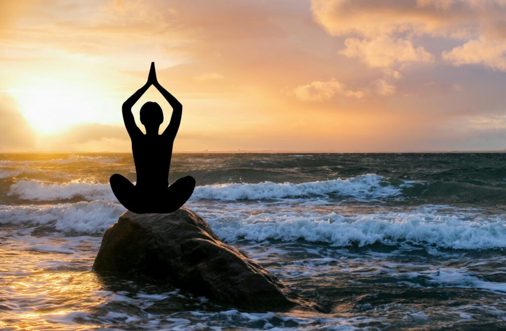 Woman holds meditation pose in sea.